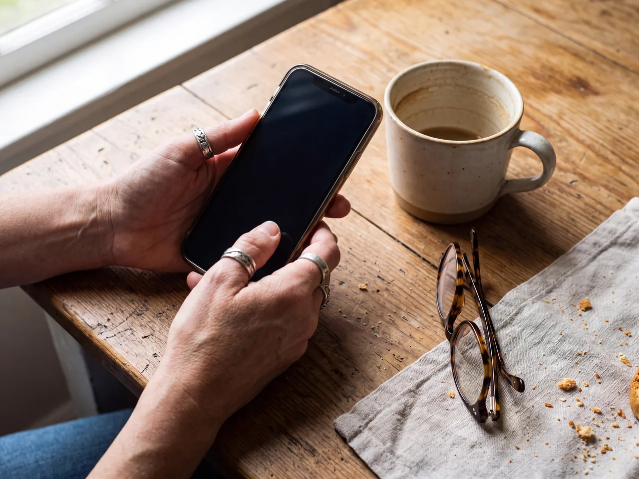 Homeowner using a smartphone at the kitchen table